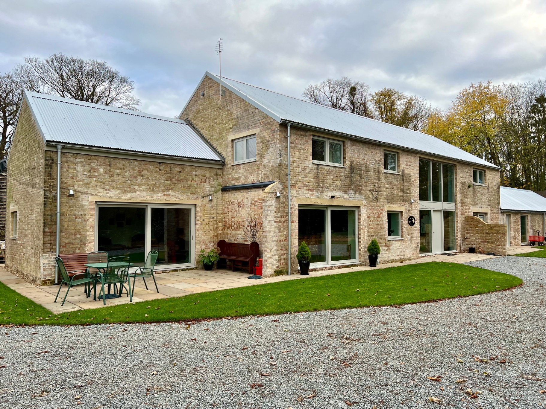 The finished parents' house — restored brick, corrugated metal roof, patio and lawn